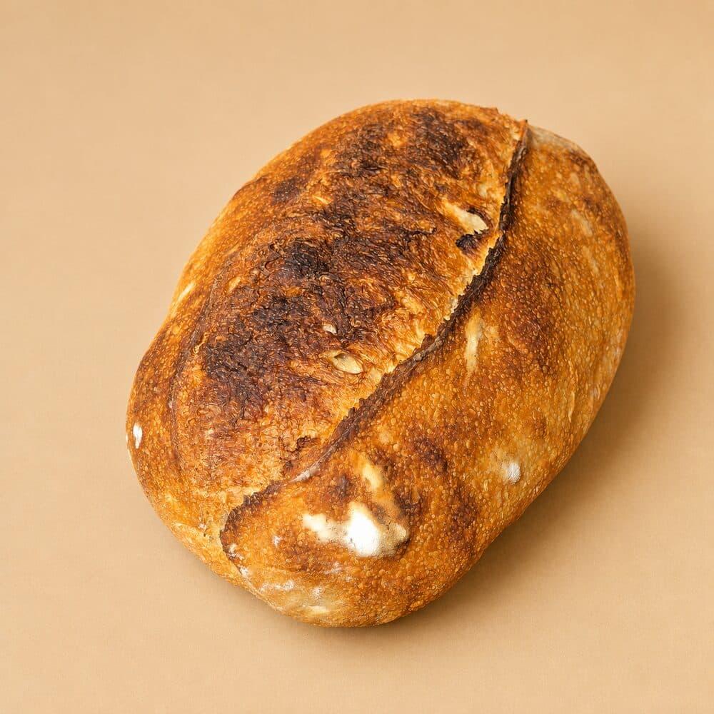 A freshly baked country sourdough loaf with a deep, crackled crust